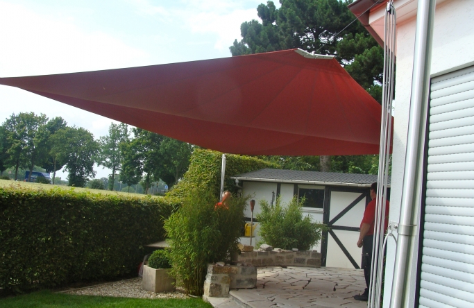 Sonnensegel - elektrisch - in NRW  in Rot über Gartenterrasse